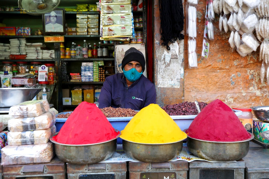 A shopkeeper wears a face mask as a precaution against the coronavirus waits for customers at a market in Bengaluru, India.