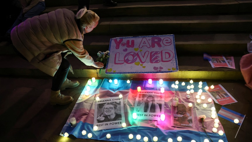 A vigil with candles and photos of a girl. 