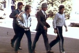 Historic photo of four men walking along