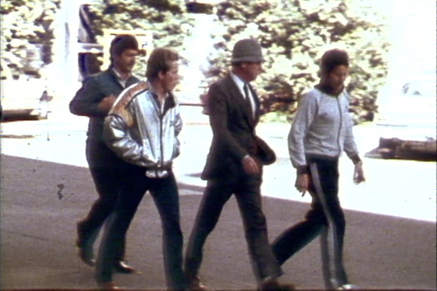 Historic photo of four men walking along