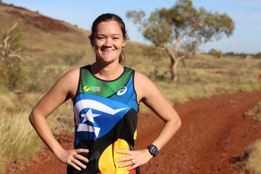 Woman in jogging gear standing in the outback.