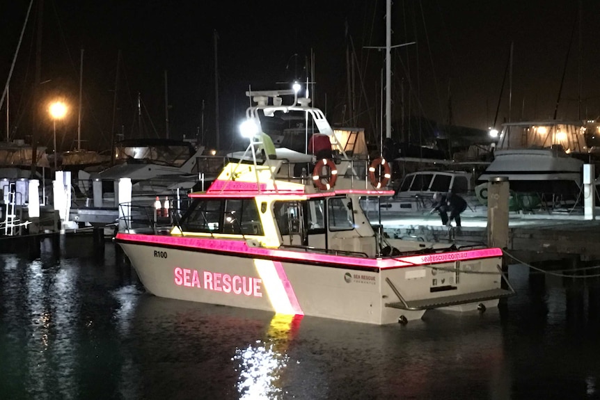 A sea rescue cabin cruiser tied up to a jetty.