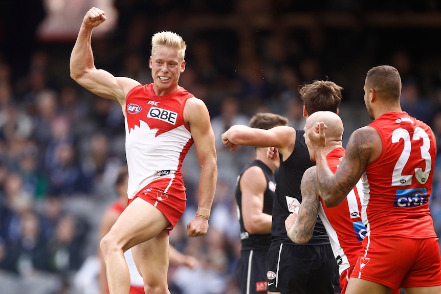 Isaac Heeney jumps in the air clenching his right fist