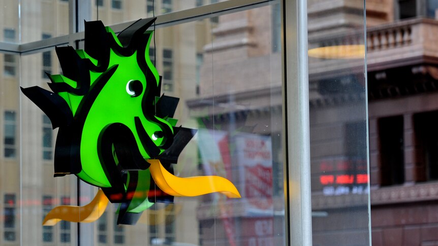 A green dragon with flames on the exterior of a bank building.
