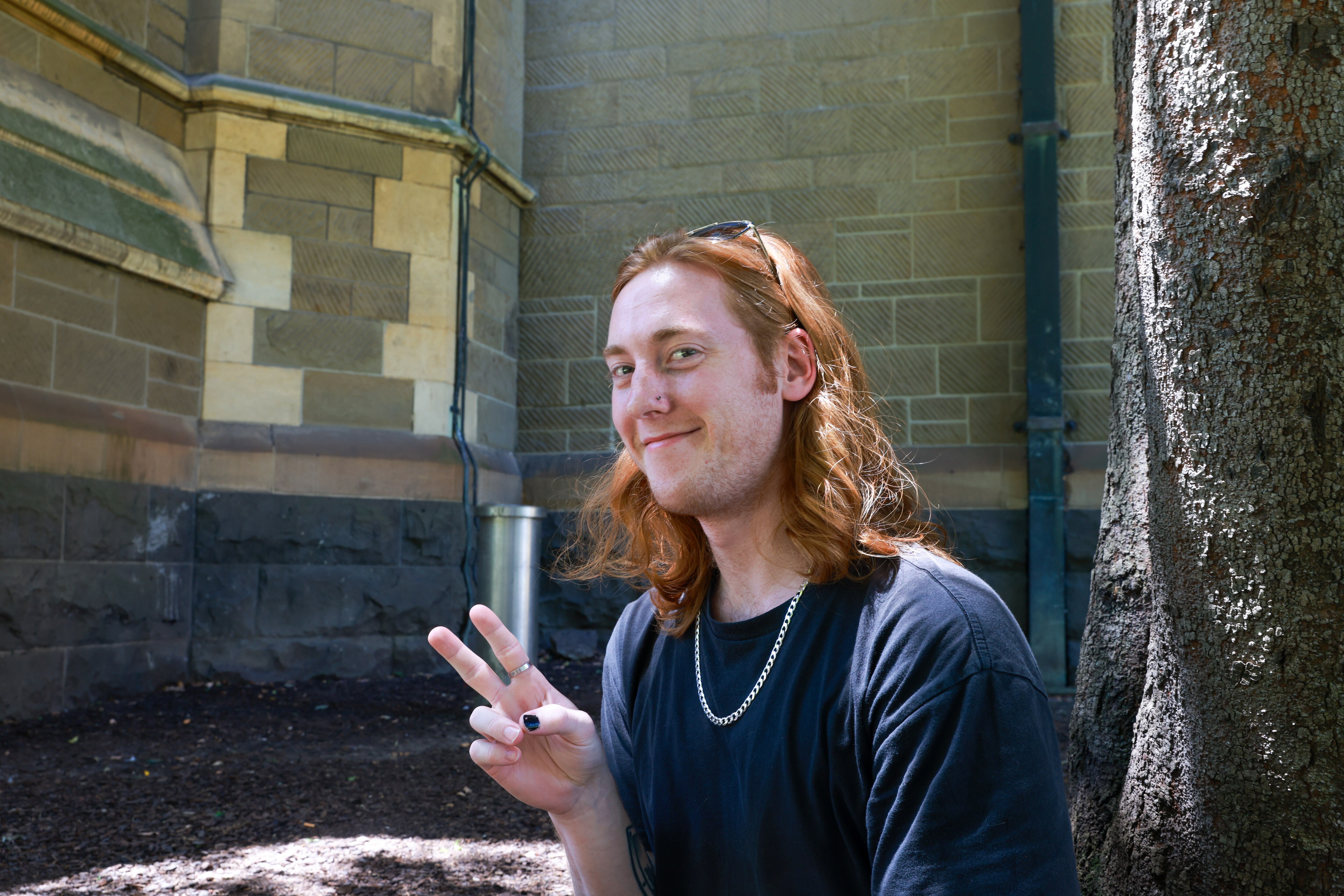 Faded social distance stickers on the footpath and people walking with masks as they pass hand sanitiser stations.