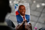 A person holds a photo of the late Haitian President Jovenel Moise