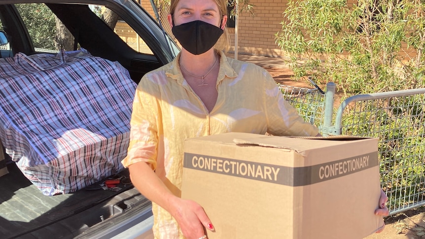 Sarah Donnelley holding care packages for Wilcannia residents