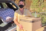 Sarah Donnelley holding care packages for Wilcannia residents