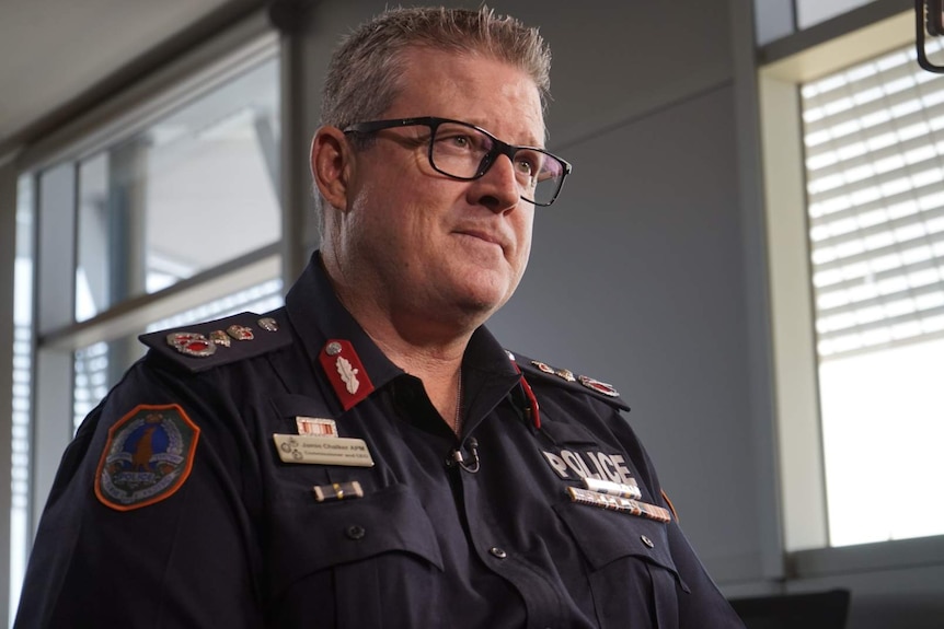 A middle-aged police officer in uniform and spectacles