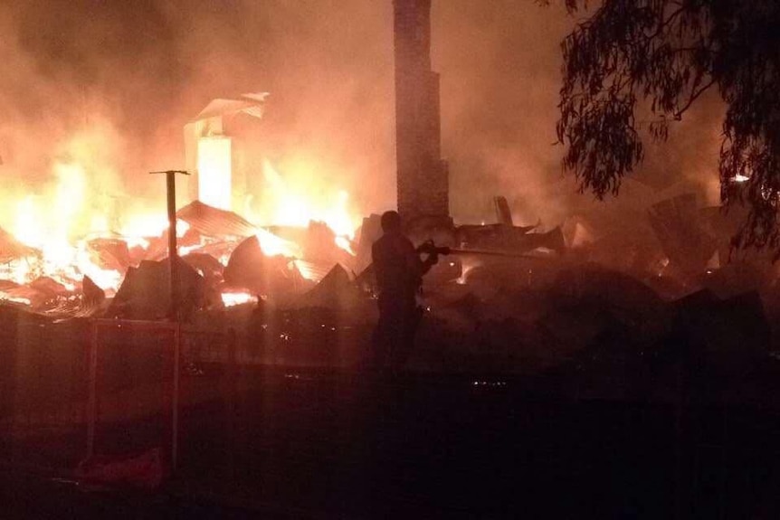 A man helps put out the blaze at the Tattersalls Hotel.