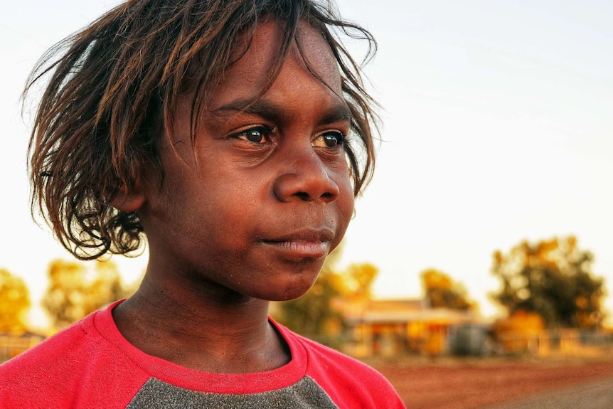 A young boy looks off into the distance.