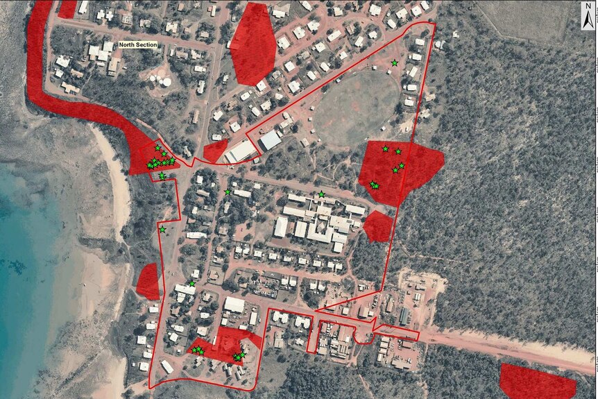 A close up aerial map of  Galiwinku properties lining the coast, with red markings highlighting asbestos sites.