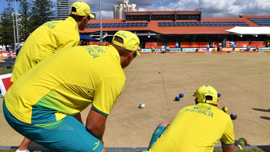 Australia's men's fours team watch a bowl from Aron Sheriff in the gold medal game against Scotland.