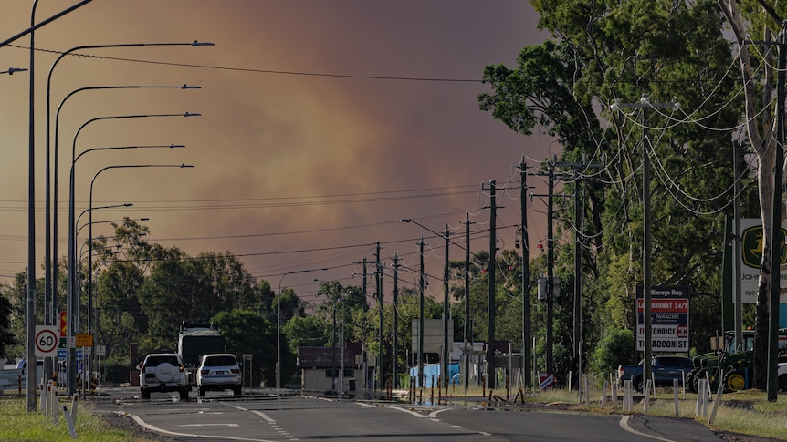 grey bushfire smoke rising over a suburban street