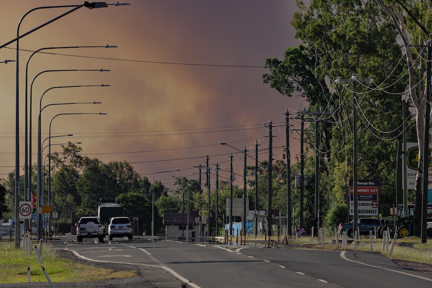 grey bushfire smoke rising over a suburban street