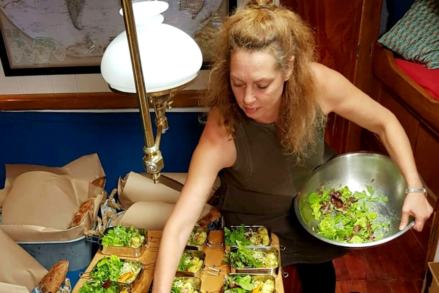  A woman is preparing food in a ship galley kitchen