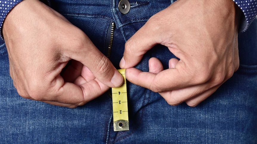 a up close photo of jeans down with someone holding a tape measure as a penis showing 4 cms