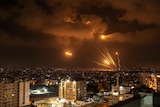 Rockets fired by Palestinian militants toward Israel cause lines of orange through the night sky.
