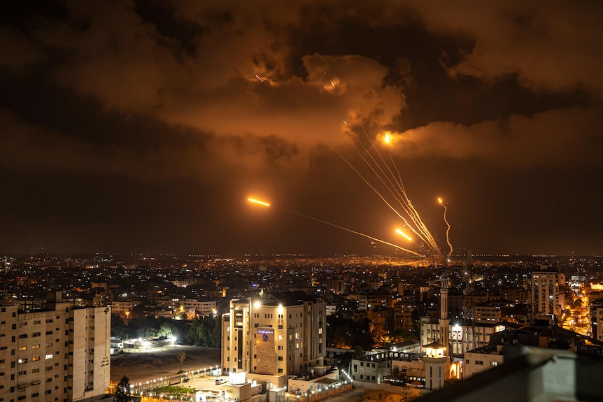 Rockets fired by Palestinian militants toward Israel cause lines of orange through the night sky.