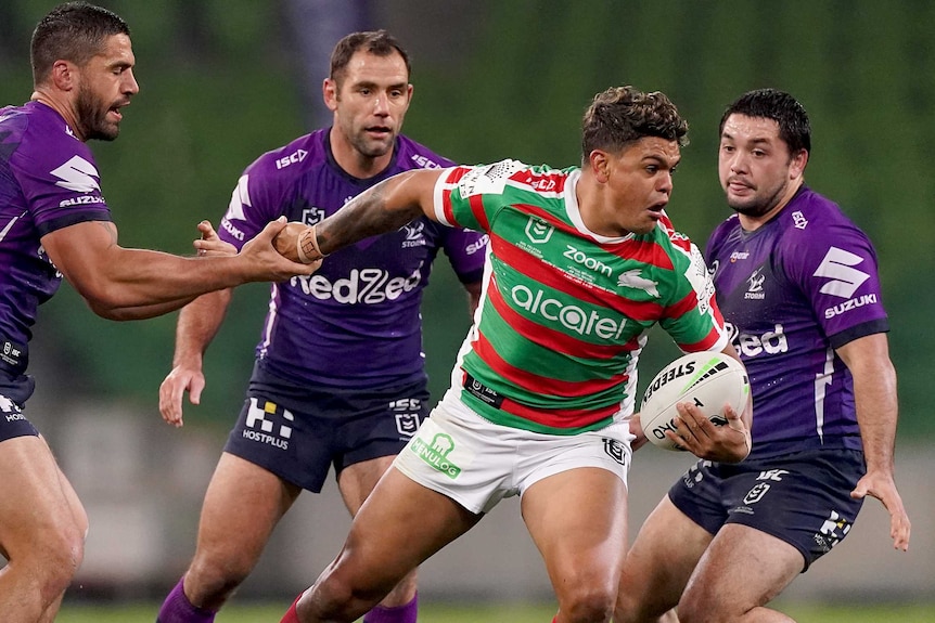 Melbourne Storm players Jesse Bromwich, Cameron Smith and Brandon Smith try to tackle South Sydney Rabbitohs' Latrell Mitchell.
