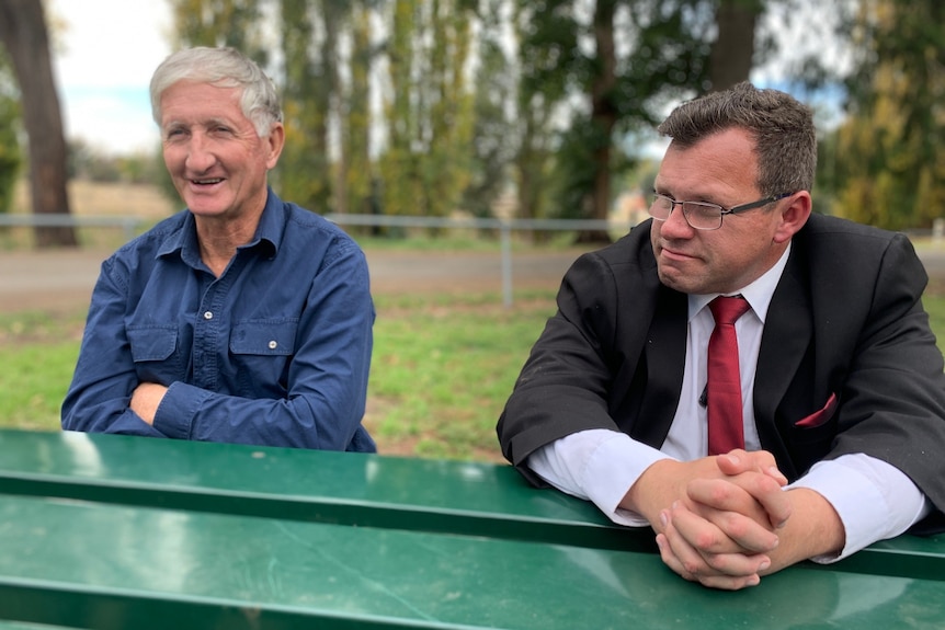 Two men seated at a park bench.