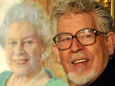 Rolf Harris posing with his portrait of Queen Elizabeth
