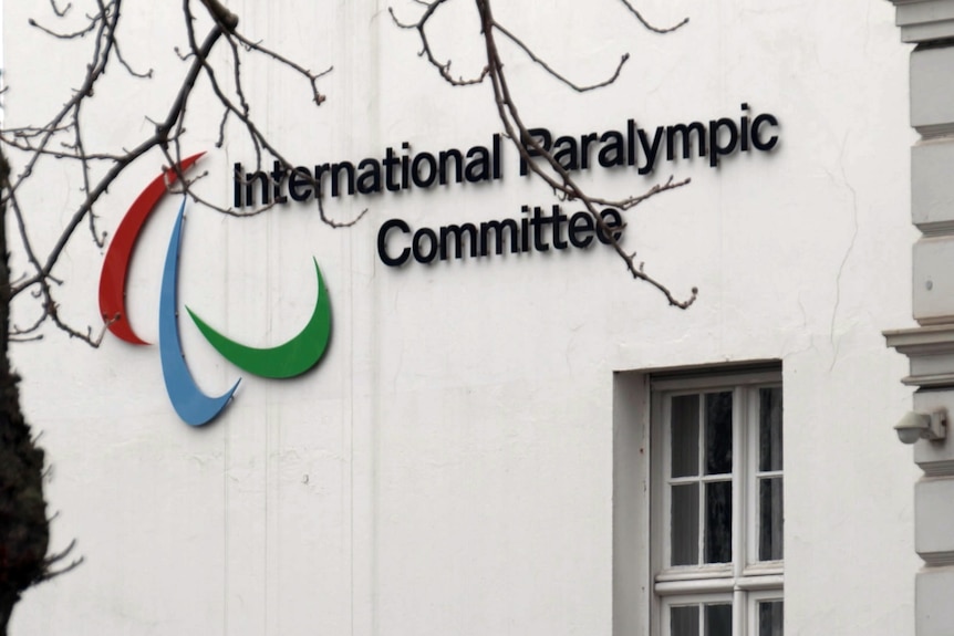 The words 'International Paralympic Committee' and the IPC logo, on the side of a white wall of a building.