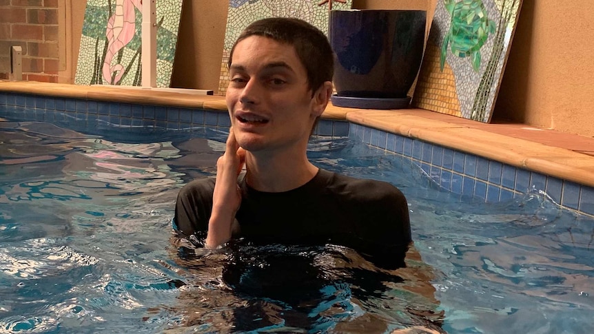 A young man swims in a pool.