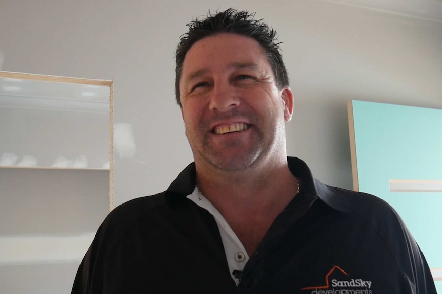 Builder Christian Serne smiles at camera in Mr Turner-Thomas' half-made home.