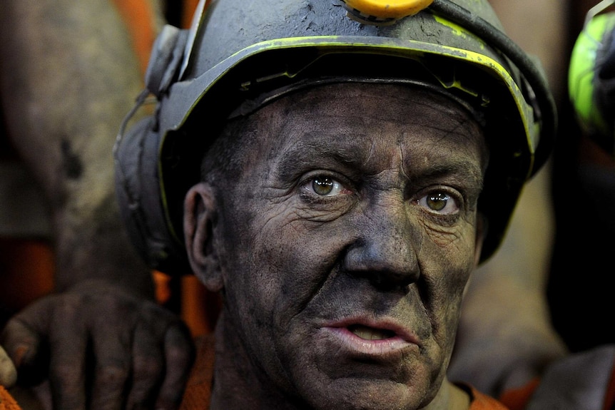 A coal miner covered in black dust
