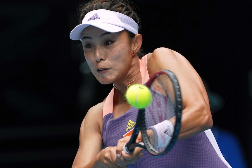 Wang Qiang plays a shot with both hands on the racquet