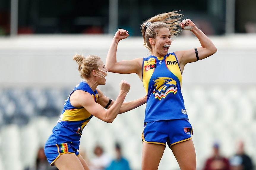 Ella Roberts pumps her fists and smiles after kicking a goal