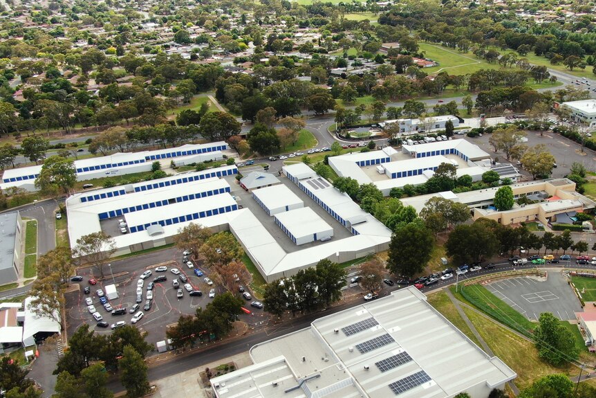 An aerial image of a testing site with a queue wrapping around several streets.