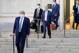 Donald Trump wearing a mask leaving the Walter Reed hospital.