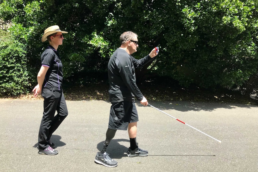 A vision-impaired man with a stick learns how to use castanets for echolocation.