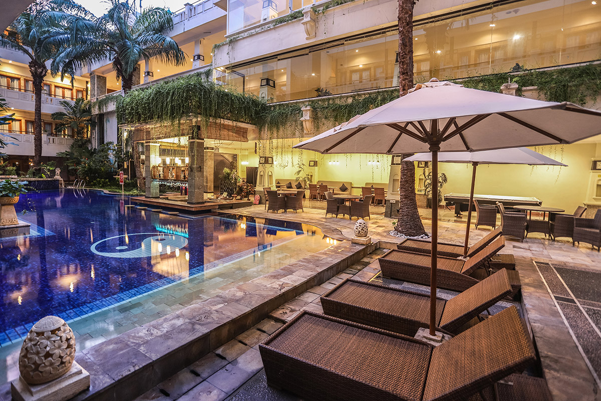 A picture of a hotel pool and some lounge beds. 