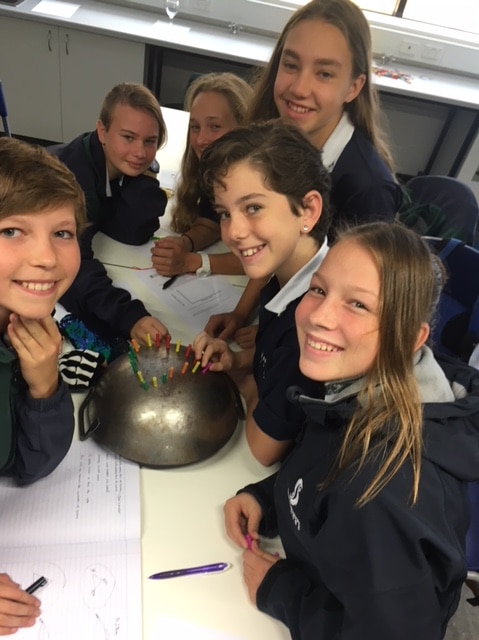 Students clustered around a wok.