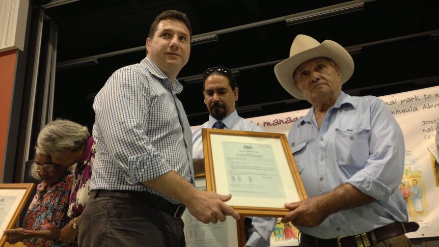 Qld Environment Minister Andrew Powell presents Deed of Grant in Trust to traditional owner Hans Pearson in Cooktown.