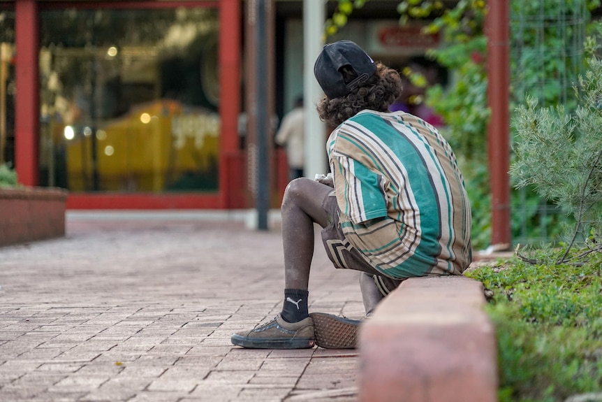 A child sits down in the Alice Springs CBD.