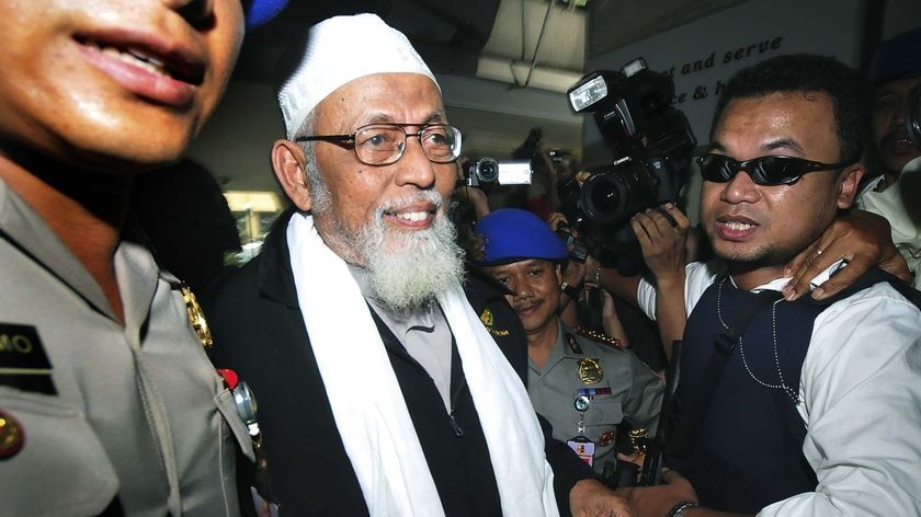 Indonesian Muslim cleric Abu Bakar Bashir is escorted by the police