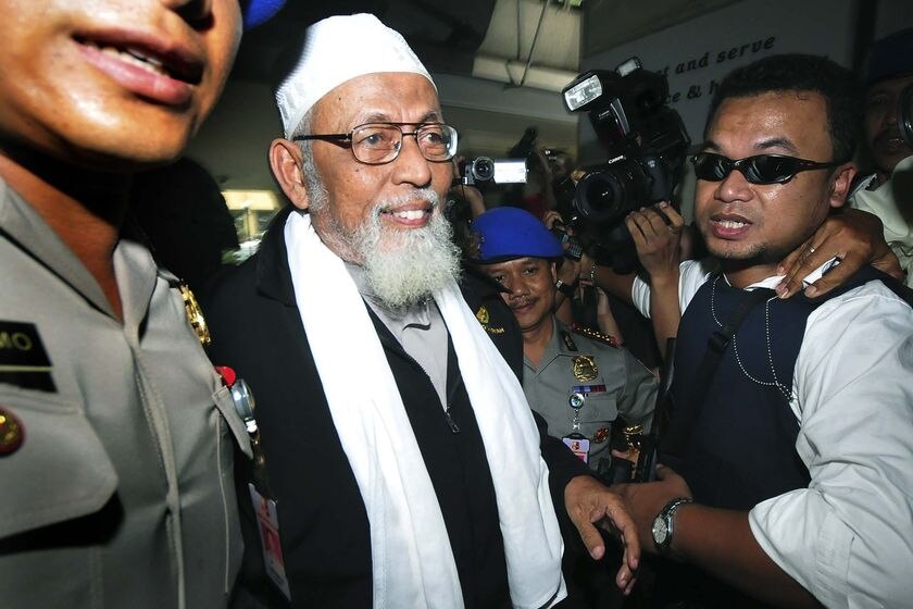 Indonesian Muslim cleric Abu Bakar Bashir is escorted by the police