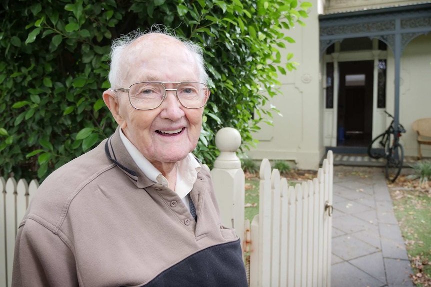 Stan McKay smiles while standing out the front of his old house