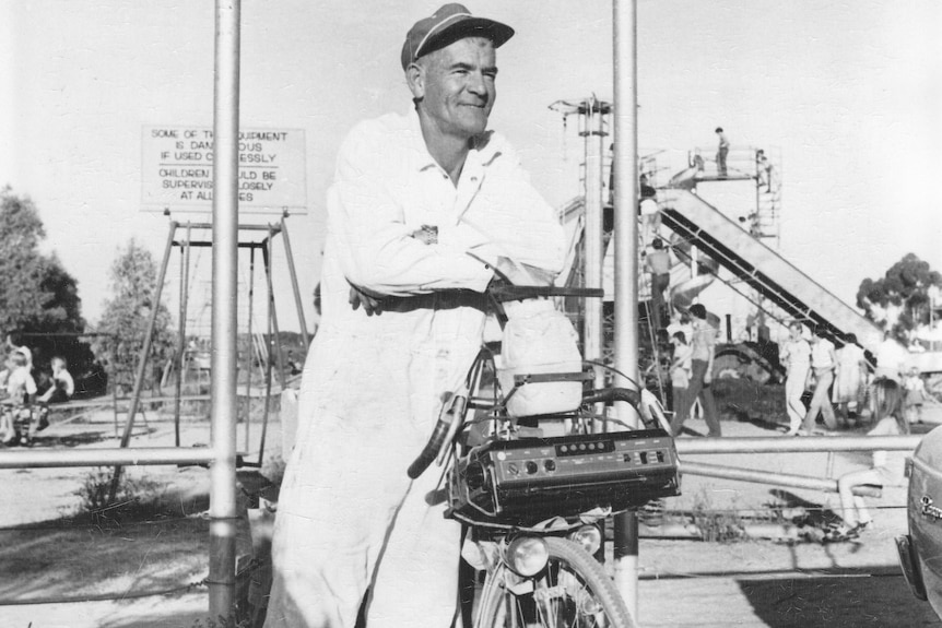 A black and white image of Grant Telfer at a playground with a sign 'Grant Park' behind him.