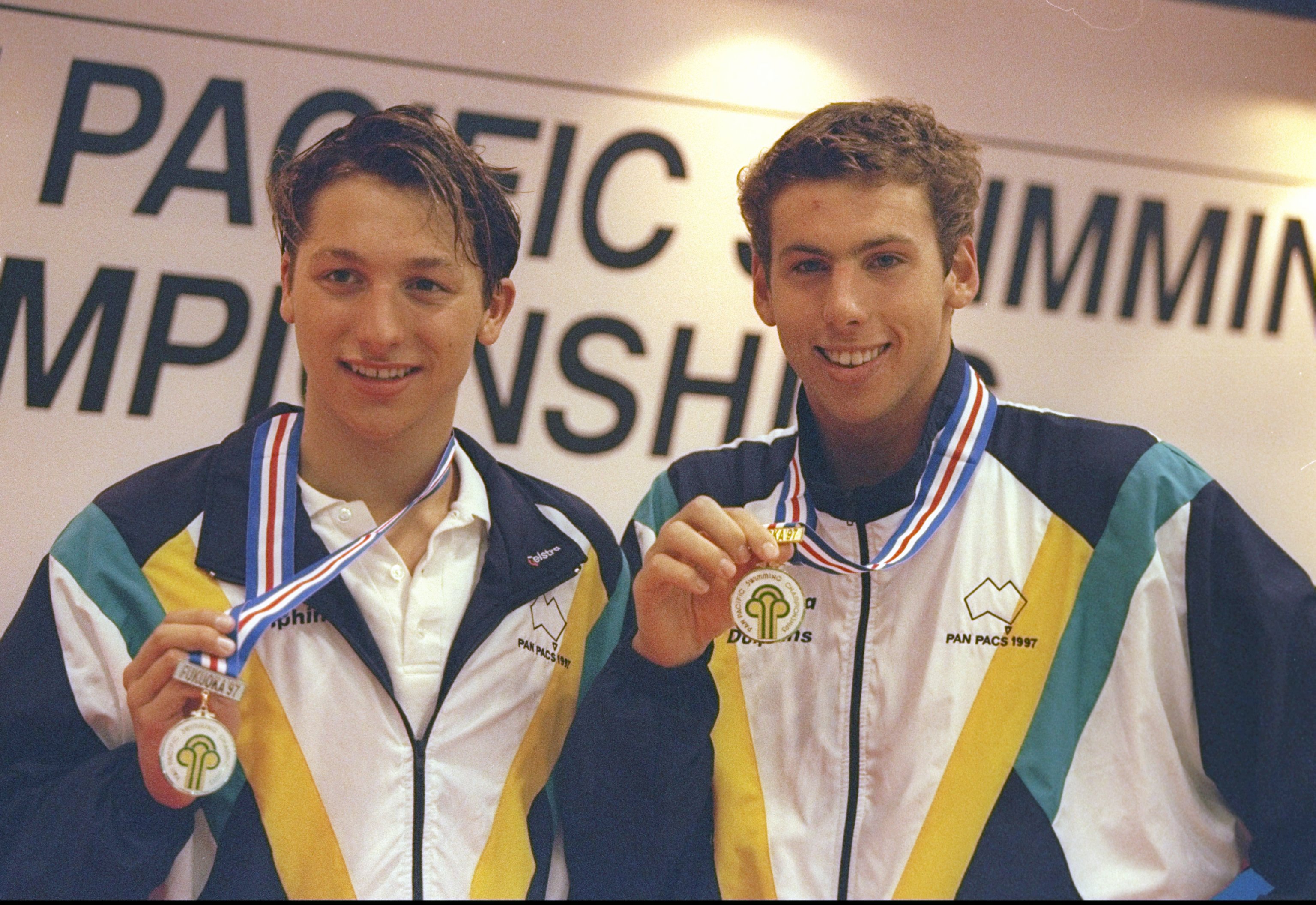Teenaged Ian Thorpe and Grant Hackett hold up medals hanging around their necks.