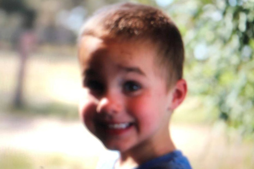 A young toddler smiling at the camera.