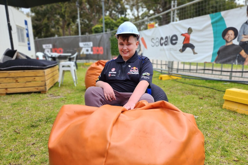 A young boy with a helmet sitting in a bean bag