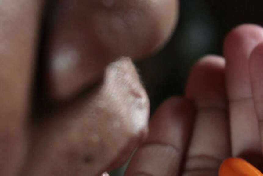 A Thai woman living with AIDS takes her daily dosage of life-saving drug Kaletra.