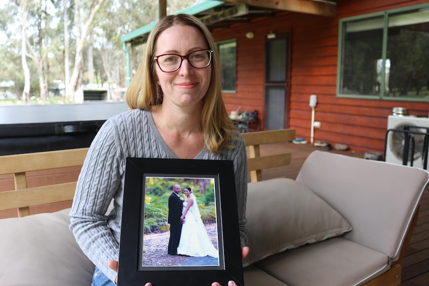 Woman holds her wedding photo.