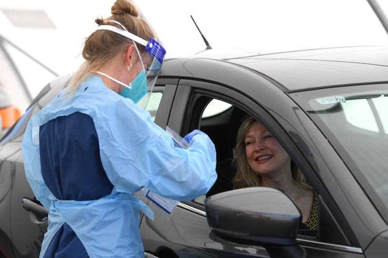 A nurse in a blue gown testing someone