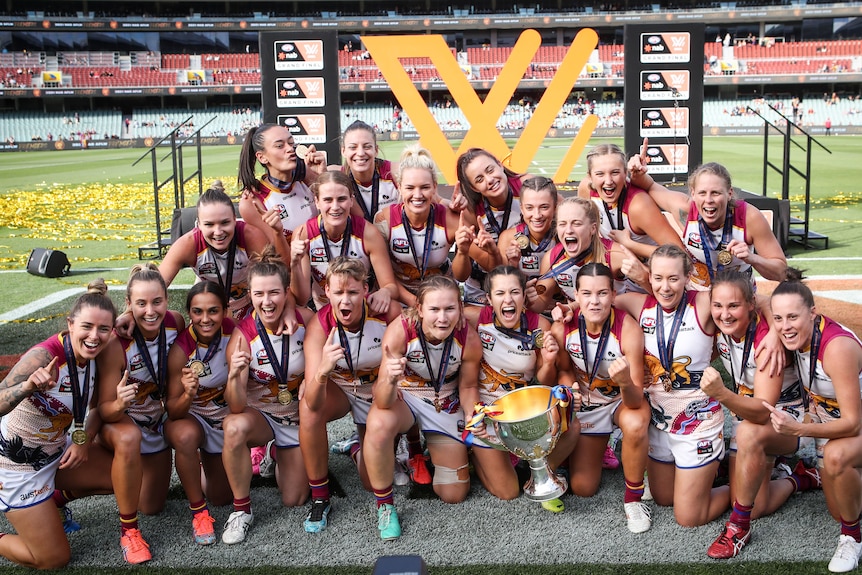 Brisbane players pose for a photo with the trophy